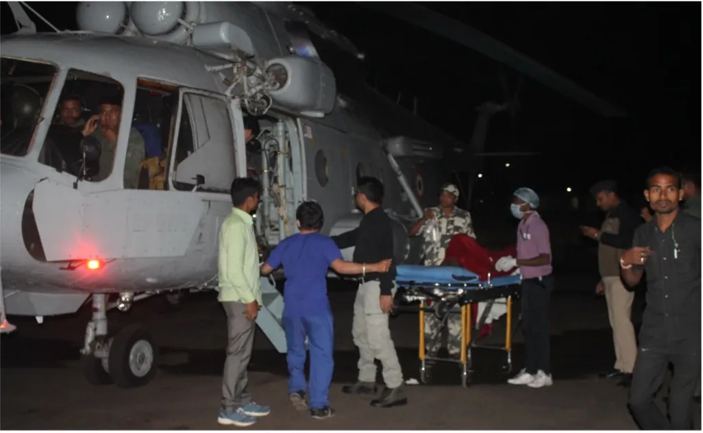 Medical staff wheel a patient on a stretcher away from an Air Force helicopter at night